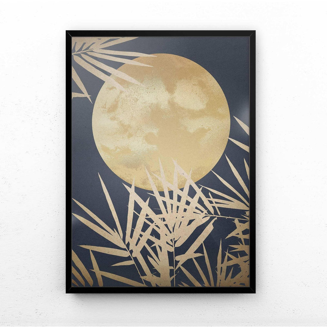 Framed artwork with a gold moon and leaf design on a dark background