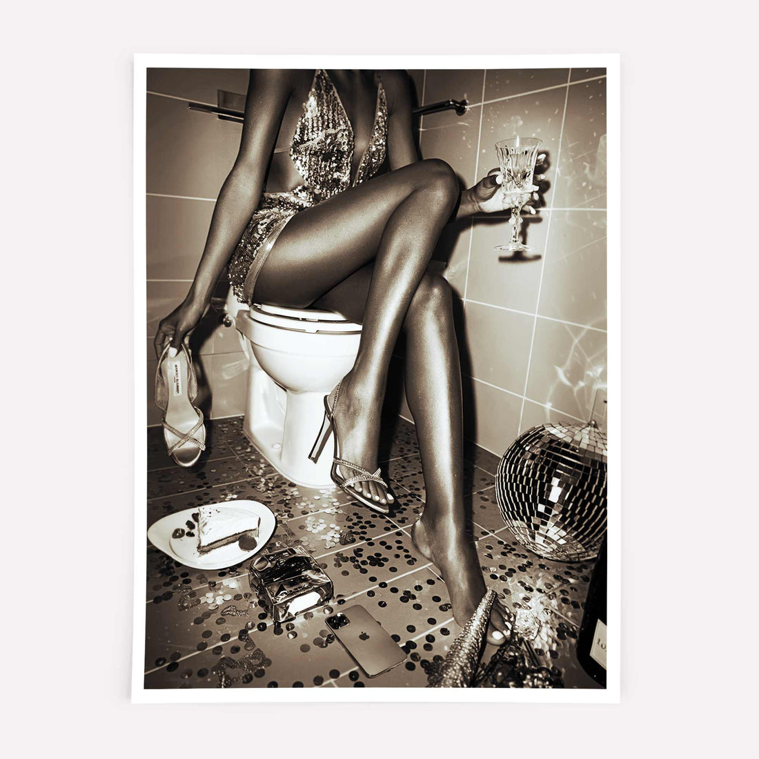 Black-and-white wall art featuring a glamorous woman in a sequined dress sitting on a toilet, surrounded by party remnants.