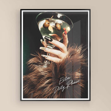 Framed artwork of a hand holding a cocktail with 'Extra Dirty Please' text on a beige wall with black frame