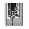Oak framed poster print featuring a girl reading a book at a french window artwork with monochrome tones and luxury French New Wave vibe. by AfterHours Gallery