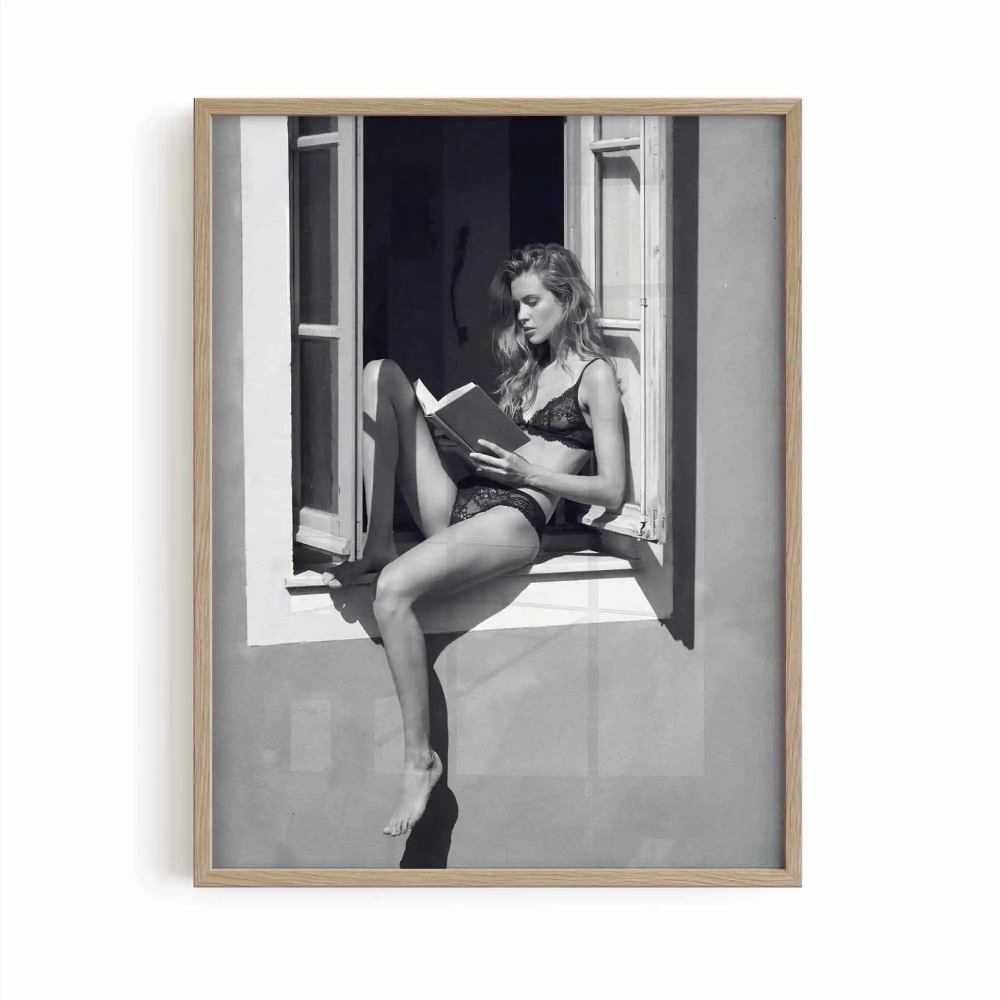 Oak framed poster print featuring a girl reading a book at a french window artwork with monochrome tones and luxury French New Wave vibe. by AfterHours Gallery