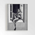 White framed poster print featuring a girl reading a book at a french window artwork with monochrome tones and luxury French New Wave vibe. by AfterHours Gallery