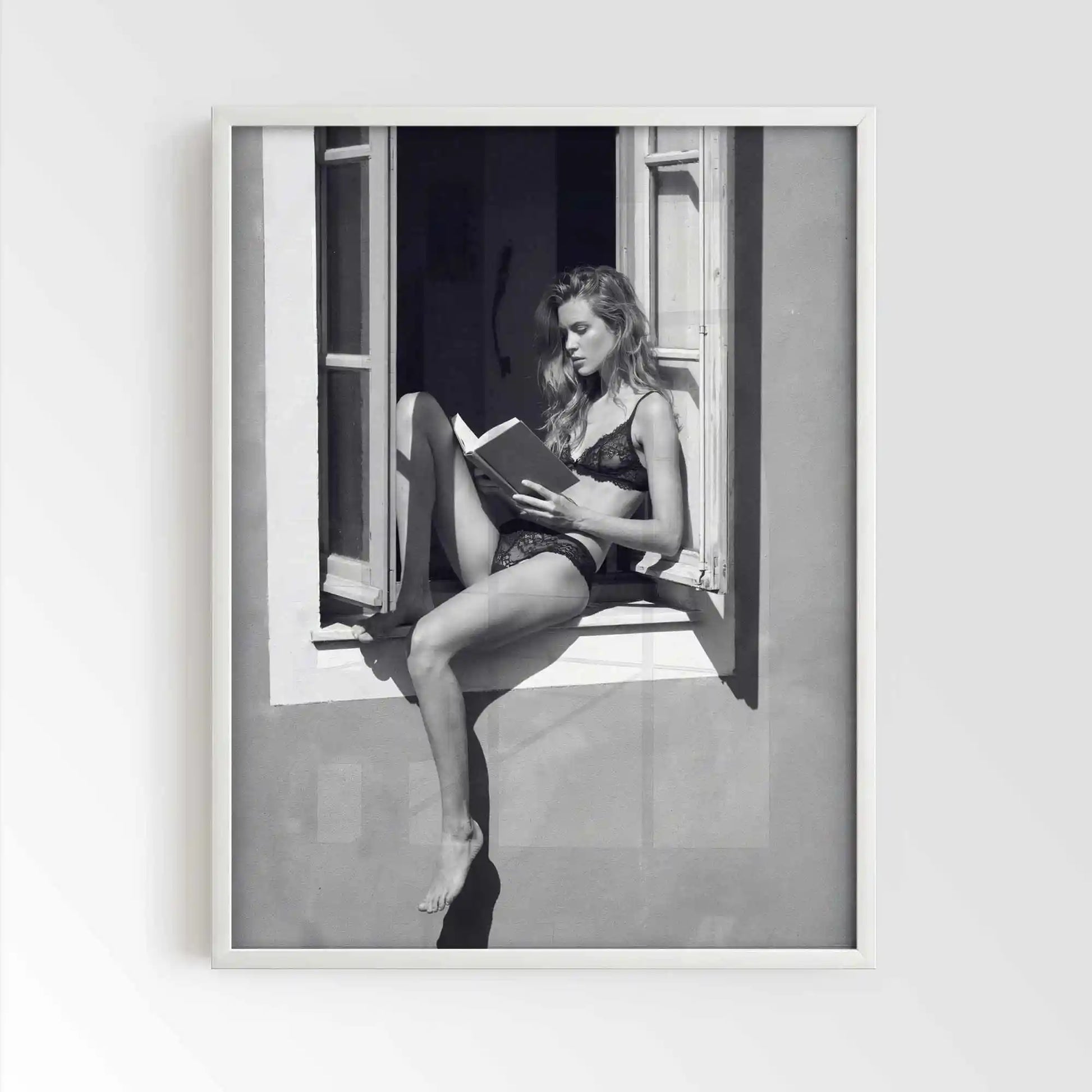 White framed poster print featuring a girl reading a book at a french window artwork with monochrome tones and luxury French New Wave vibe. by AfterHours Gallery