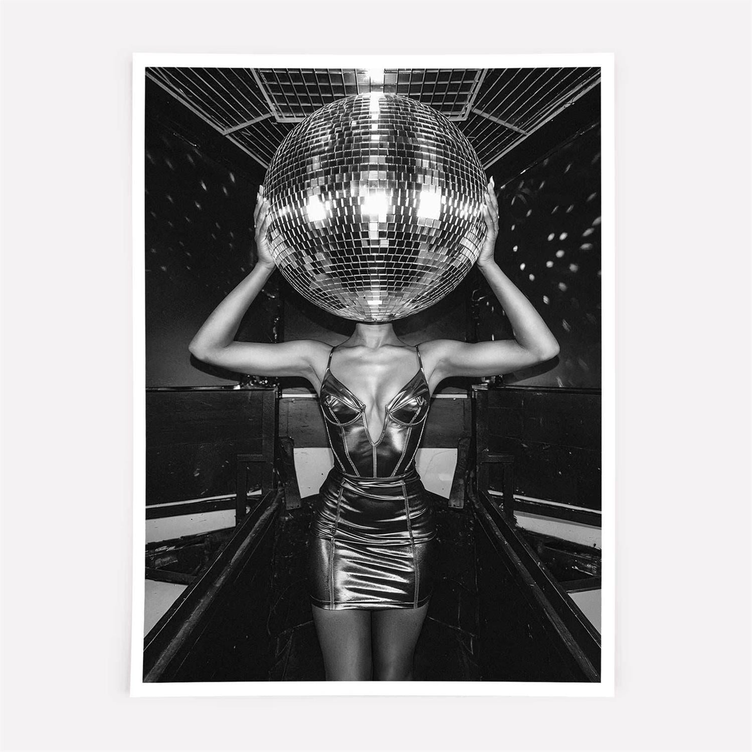 Person wearing a metallic dress holding a large disco ball in a club setting