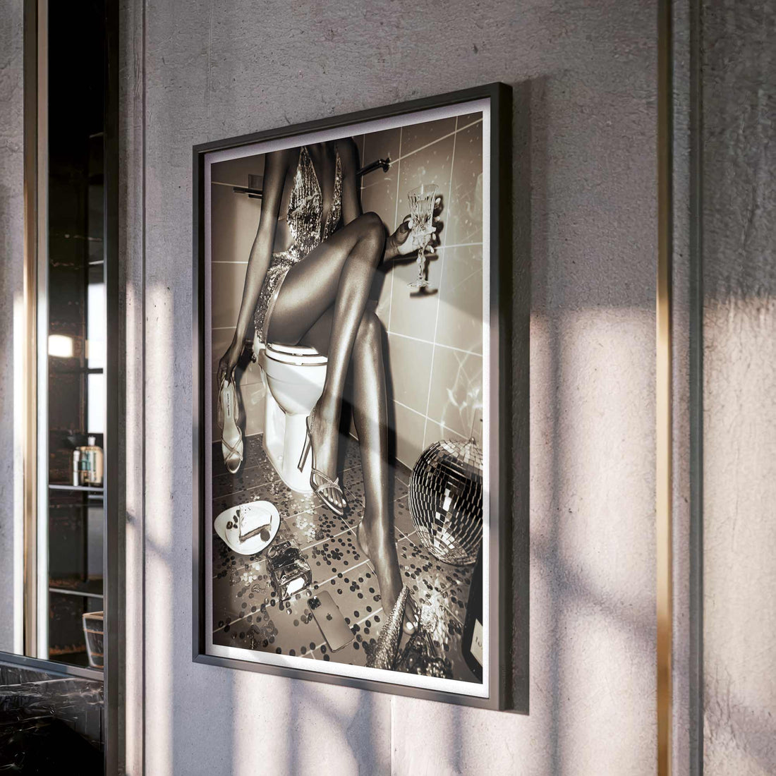 Black-and-white wall art featuring a glamorous woman in a sequined dress sitting on a toilet, surrounded by party remnants.