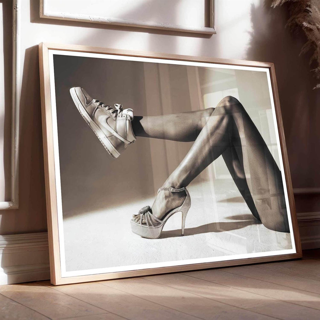 Framed black and white art print of a woman's legs in tights and high heels with black frame