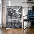 Framed poster with 'In Cinema Today' text in a room with a black chair.