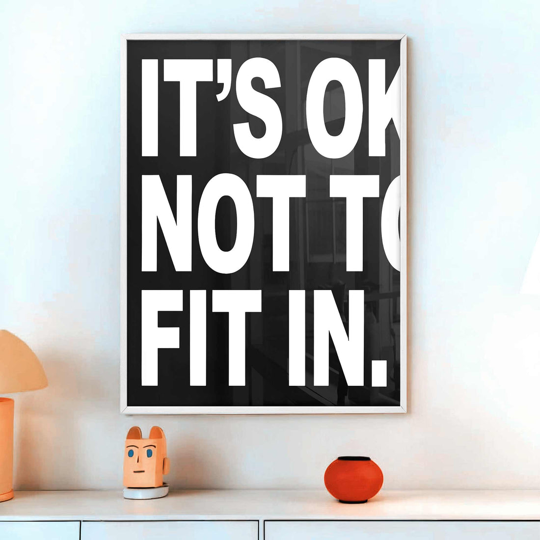 Poster with bold “It’s OK Not to Fit In” quote in black and white