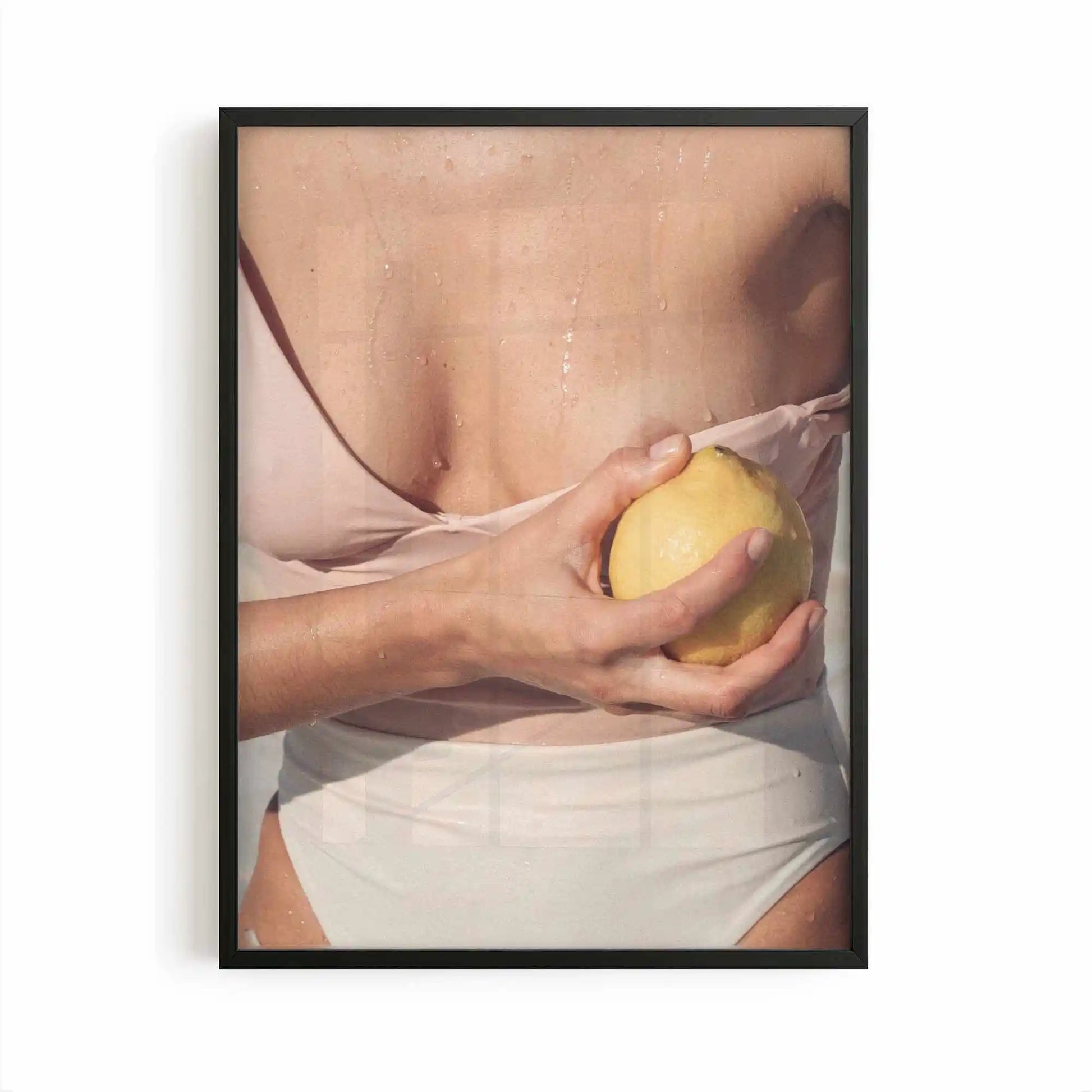 Editorial Mediterranean photography framed print showing a fresh lemon held against sun-kissed skin with soft neutral tones and warm citrus colours.