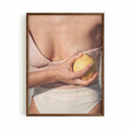 Editorial Mediterranean photography framed print showing a fresh lemon held against sun-kissed skin with soft neutral tones and warm citrus colours.